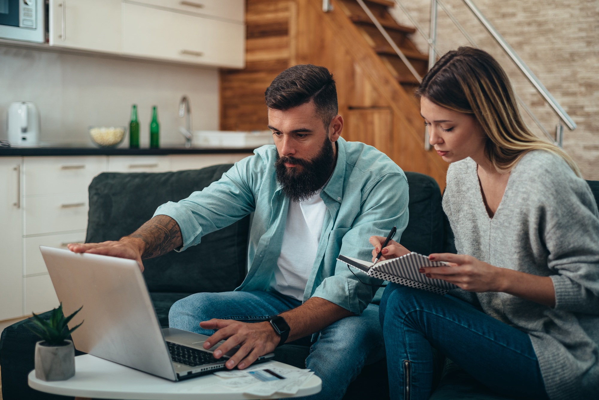 Young beautiful couple using a laptop for calculating their monthly budget
